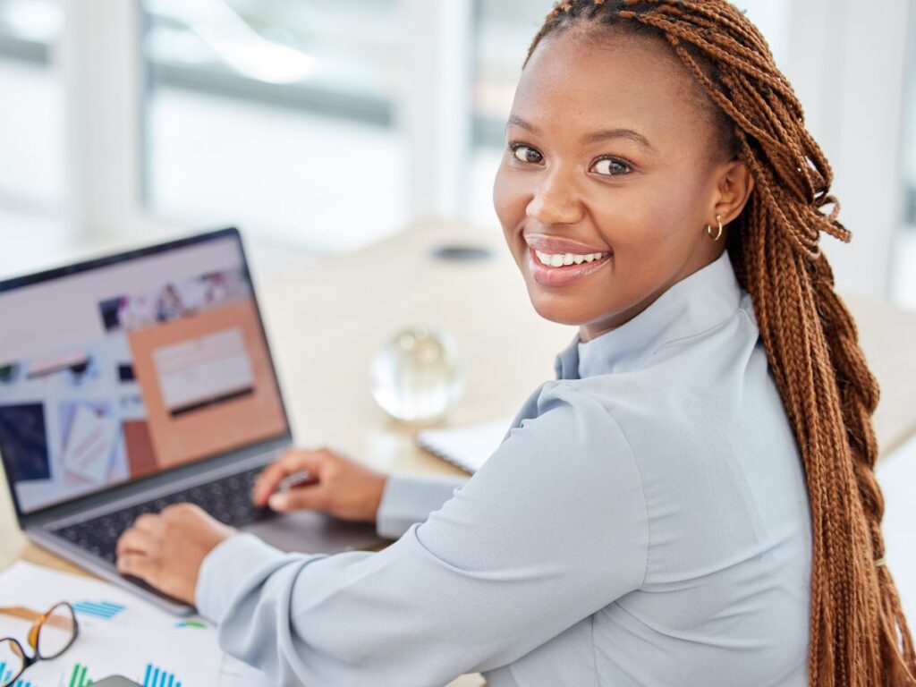 Smiling professional working on SEO tasks at office desk