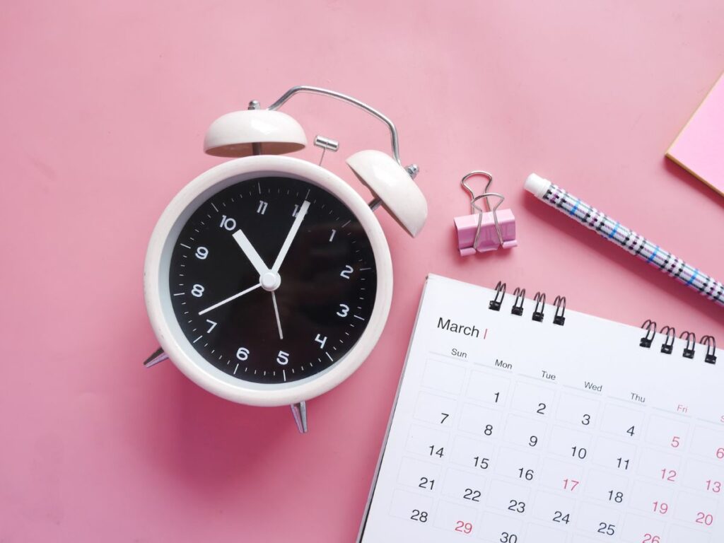 Alarm clock beside a March calendar
